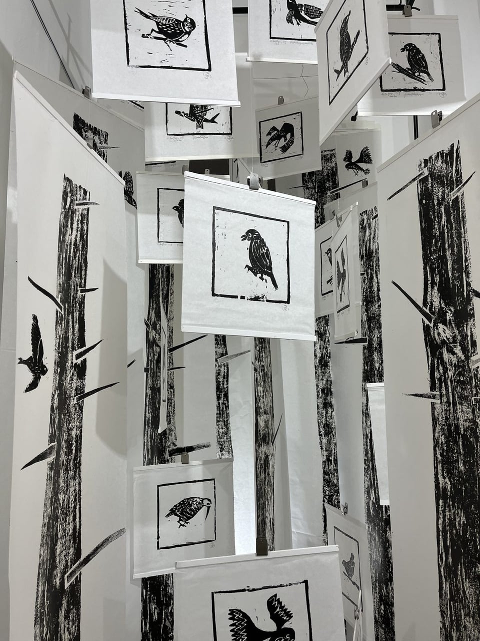 Exhibition display with prints on freely hanging panels