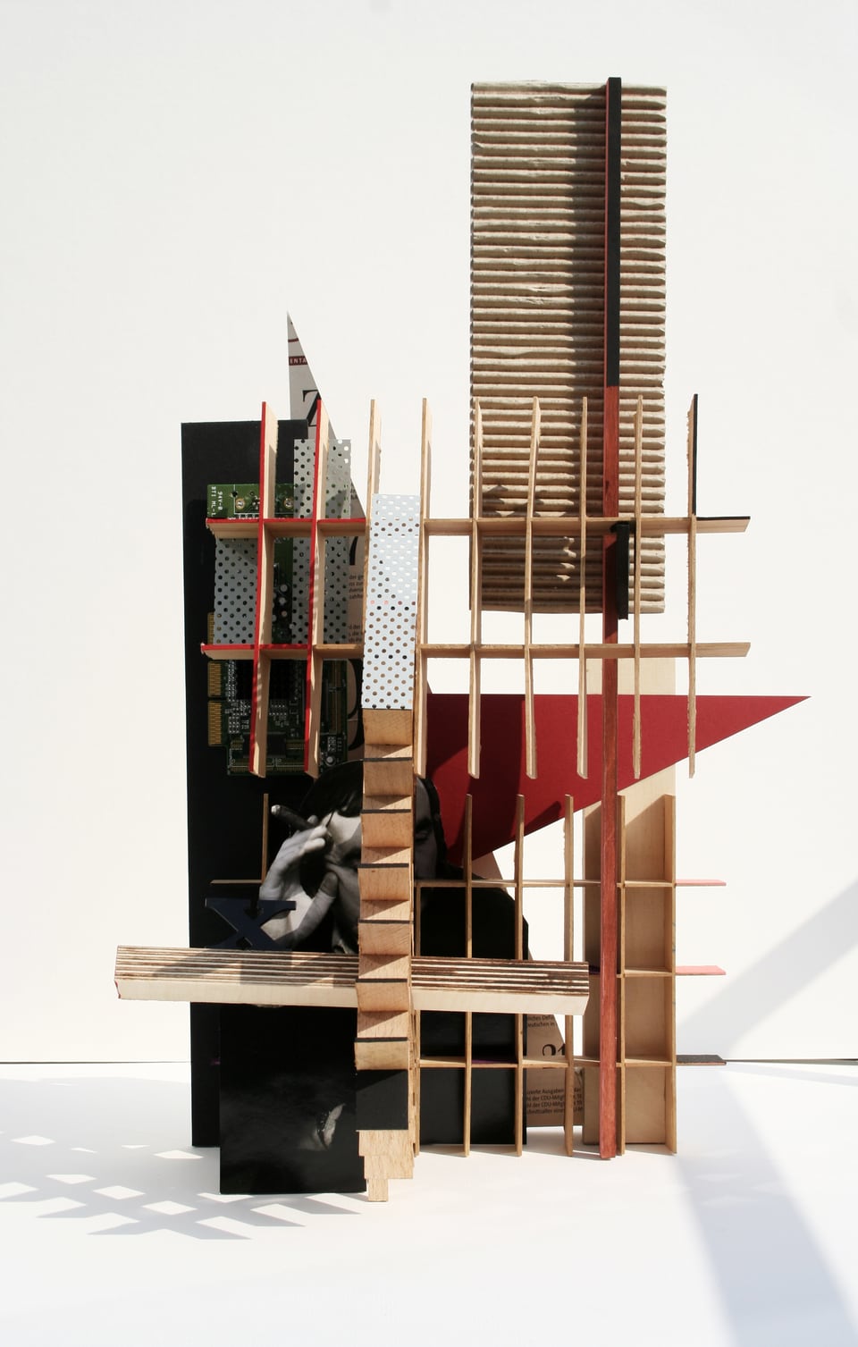 Michael Thomas Schröder, Untitled – wall object of wooden grids, corrugated cardboard, black panels, a red triangle and photo collage