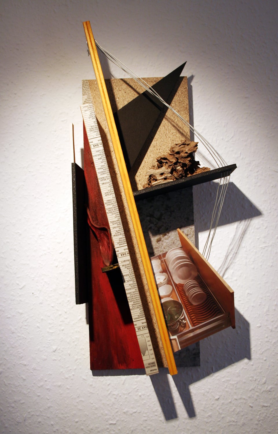 Michael Thomas Schröder, Untitled – wall object of chipboard, red-painted wood, a yellow slat, wire, stock prices and a photograph of a crockery drawer